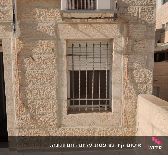 יחידת מיזוג אוויר מותקנת על קיר אבן חיצוני
